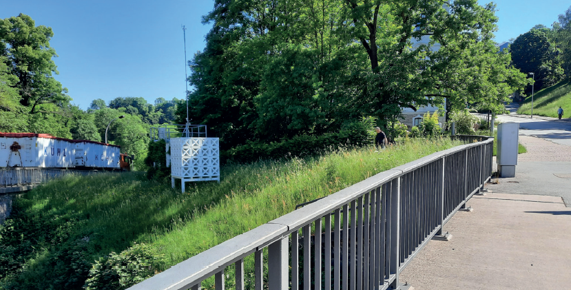 Querformat Bild von dem Ort, an dem unser Cube steht, man sieht ihn mittig-links im Gras stehen.